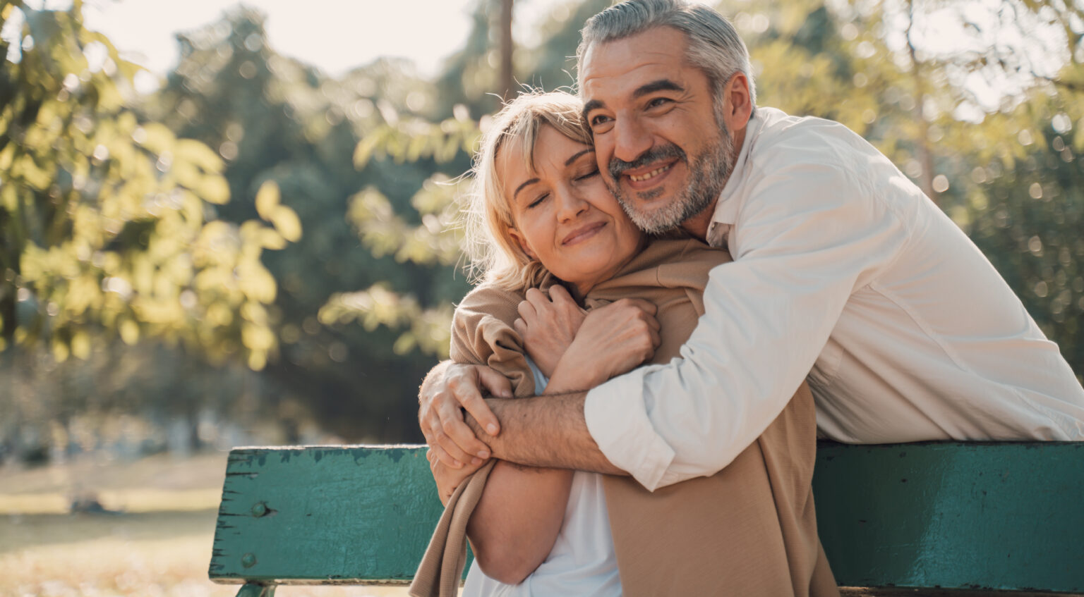 Senior couple hugging in a park.