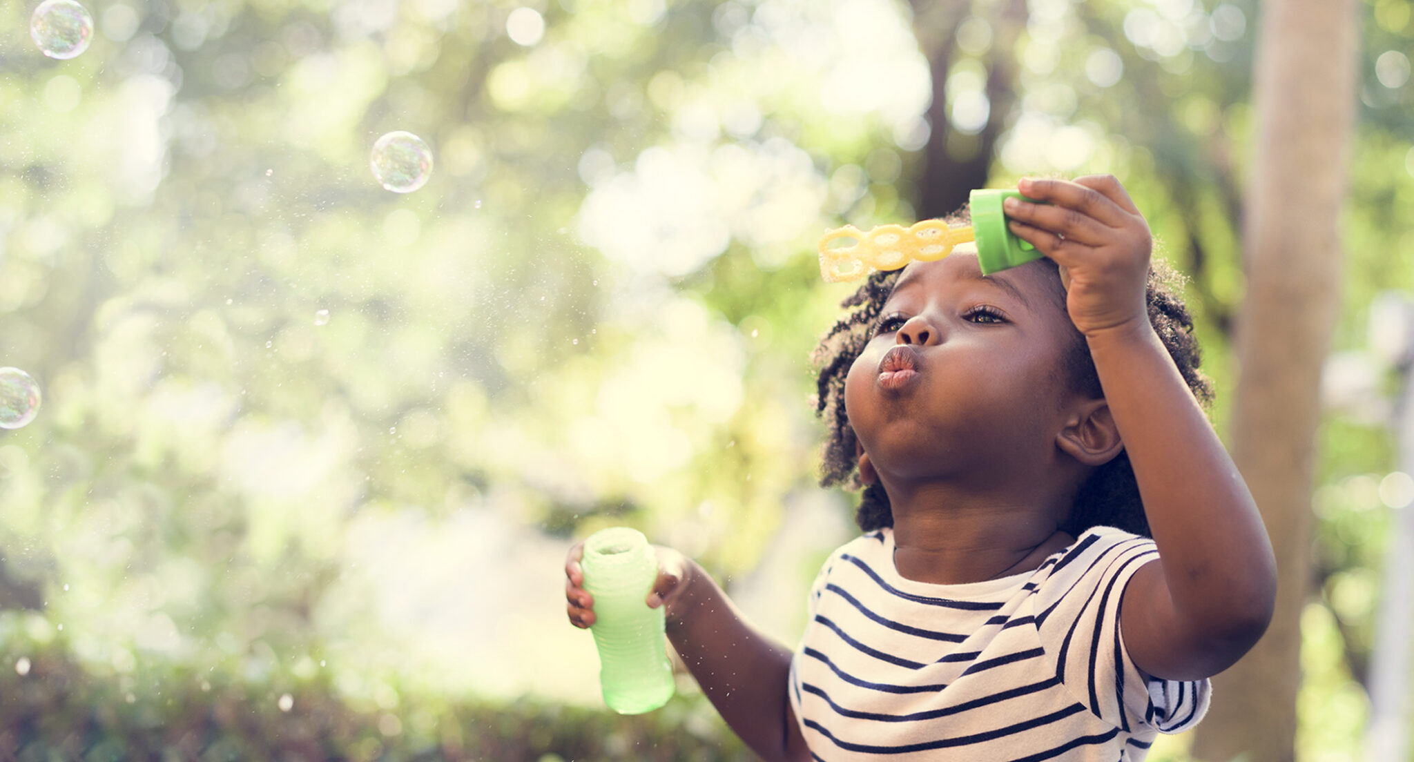 Little girl blowing bubbles.